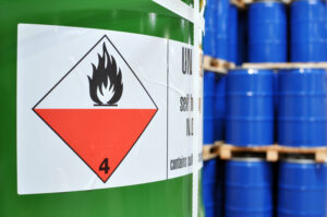 Green chemical container that has label with warning flame. 