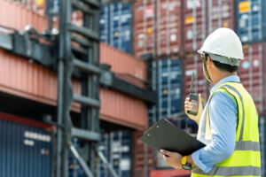 A man with a clipboard looking at shipping containers in El Paso.